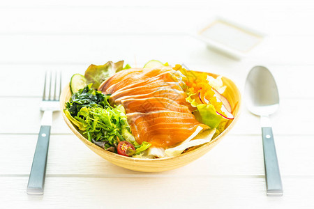 生鲜三文鱼肉生鱼片配蔬菜沙拉和酱汁图片