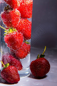 带气泡的玻璃杯中的草莓特写图片