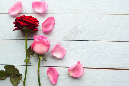 木制背景情人日或婚礼贺卡上的红玫瑰和粉红色玫瑰图片