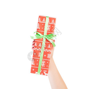 女人的手用红纸用绿丝带包裹圣诞节或其他节日手工制作的礼物图片