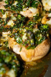 用奶酪大葱和莳萝在烤箱里烤的蘑菇特写图片
