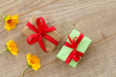 带有红色丝带和木本上美丽的甘菊花的礼品盒节假日赠送礼物的概念顶端视图图片