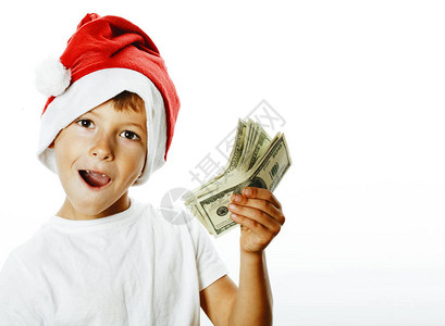 穿着圣塔红帽子的可爱小男孩被美国现金用大拇指夹在快乐的孩子节图片