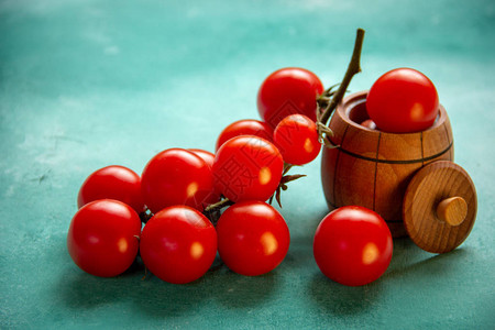 红樱桃西红柿的枝子一个小木桶蓝底有图片