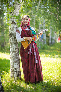 穿着传统俄罗斯服装的年轻有思想的女人背景图片