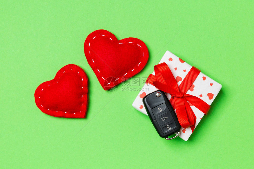 礼物盒上的车钥匙和背景丰富多彩的红纺织心的最顶端视图为情人节图片
