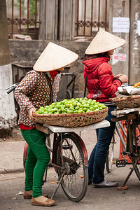 中越边境老凯街上的水果摊贩戴着NonLa或越南帽子的越南妇女街头小贩图片