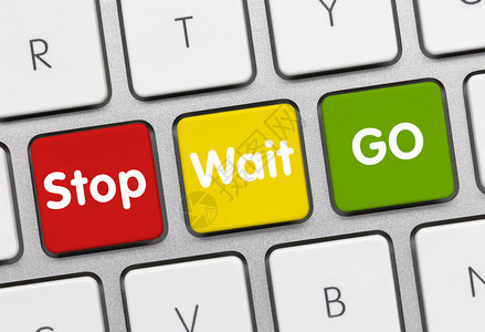 STOP与GO写在金属键盘的红黄绿键背景图片