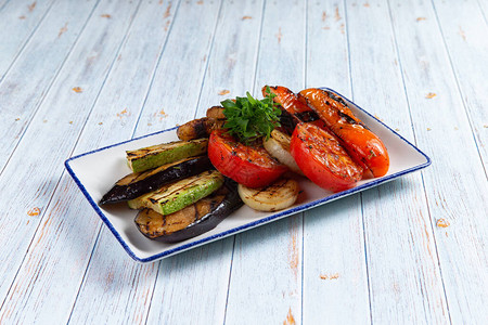 装饰盘子里的油炸蔬菜在木制背景上图片
