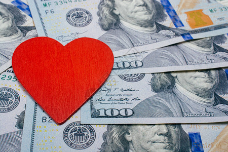 红心在美元钞票上卖爱换钱的概念图片