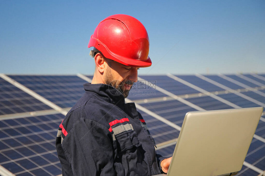 红色头盔和太阳能发电厂笔记本电脑中的电图片