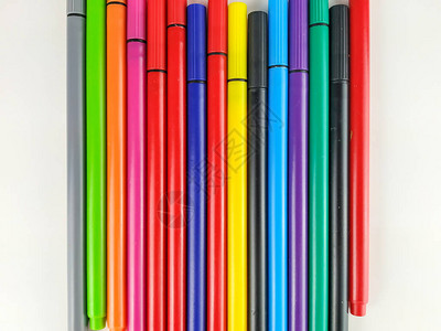 学生和孩子们用来记笔和着色的白色背景上随机排列的许多彩色笔的特写图片