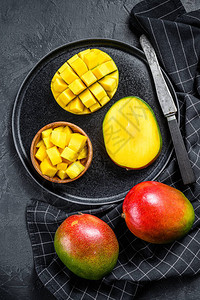 一个成熟的芒果切入立方体热带水果黑色背图片