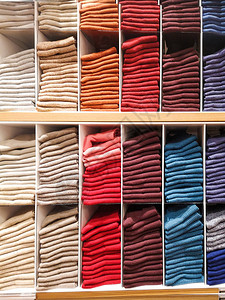 服装店的货架上摆着T恤T恤袜子连裤袜以彩虹色折叠的长筒袜粉色黑色灰色图片