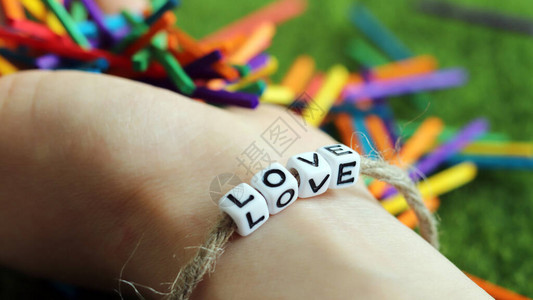 木制彩虹色棒和LOVE文字立方体的手镯图片