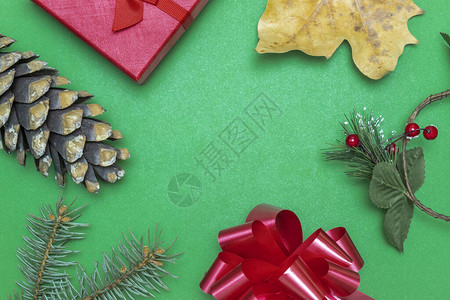 用红色礼盒松枝红弓松果和黄色干秋叶制作的圣诞和新年贺图片