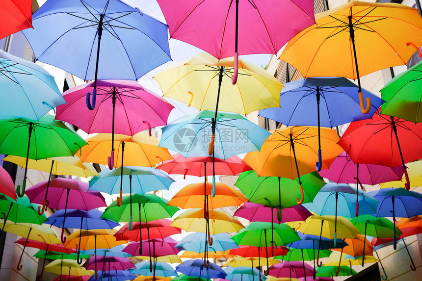 五颜六色的雨伞五彩的虹挂在大街上图片