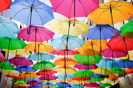 五颜六色的雨伞五彩的虹挂在大街上图片