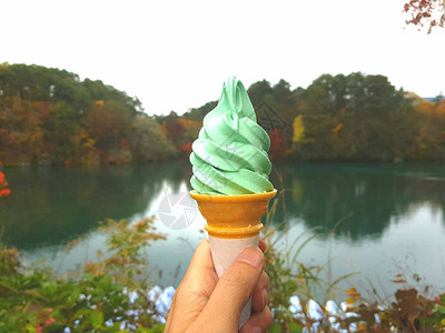 手拿着冰淇淋在日本福岛的锥形湖中图片
