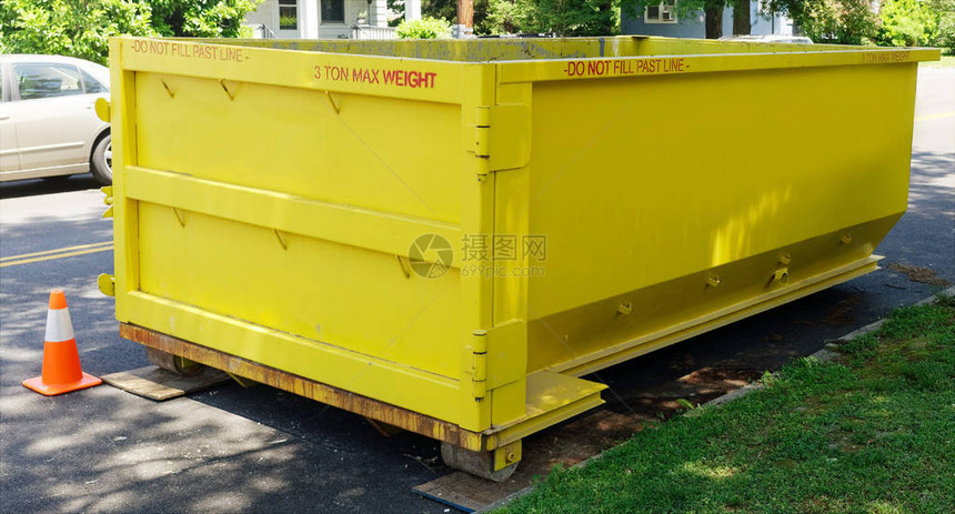 新油漆的黄色工业垃圾箱集装箱存放在街坊道上面印图片