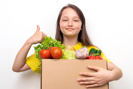 带着一盒蔬菜的快乐女孩举起大拇指图片