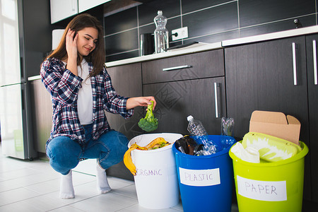 特写概念在家中分类垃圾有三个桶用于不同类型的垃圾年轻女子在厨图片