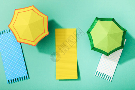绿松石背景下纸巾和雨伞的顶部视图背景图片