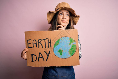 要求保护地球的年轻美女拿着纸板庆祝地球日严肃的脸思考问题图片