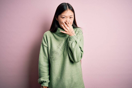 年轻美丽的亚洲女人穿着绿色的冬季毛衣图片