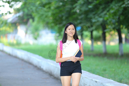 黑头发的女孩少女在鲍勃白色东亚女人绿色公园与背包景图片