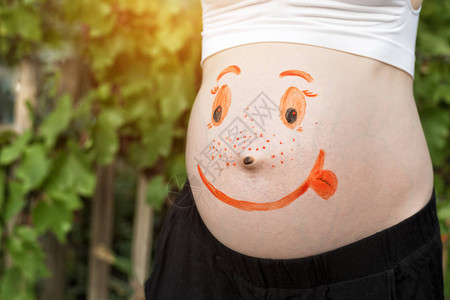 身着面容微笑的画像的孕妇的肚图片