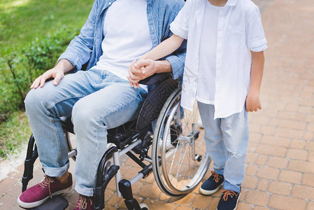 与坐在轮椅上残疾父亲的双图片