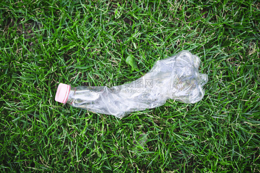 绿色草地上的塑料瓶顶尖视图片