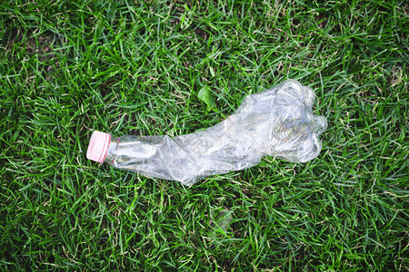 绿色草地上的塑料瓶顶尖视图片