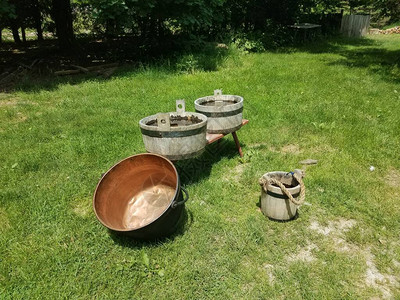 绿草中带水的木桶和铜锅图片