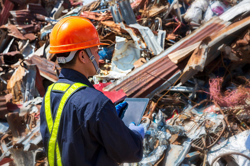 工程师和可回收材料一位工程师正在寻找回收废物继续下一个过程工头穿着防护设备图片