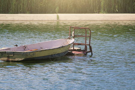 一艘生锈的旧船停泊在淡水池塘里图片