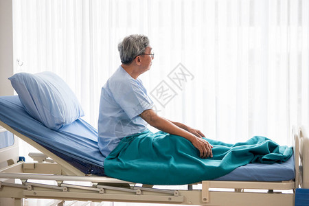 亚洲病人男坐在医院的病床上躺在图片