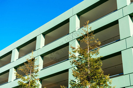 多层停车场的外墙和外墙前景绿树图片
