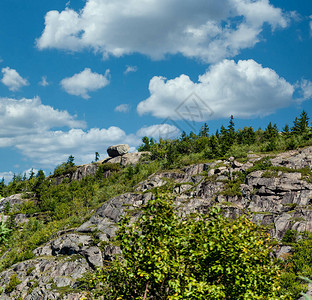 蓝天下一座陡峭的岩石山上图片