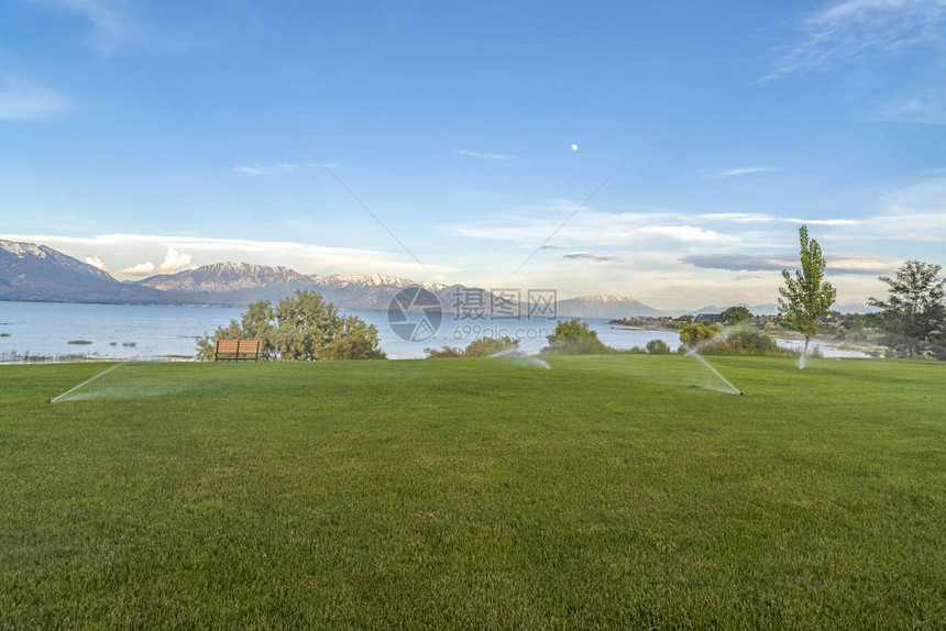 蓝湖雪山和天空风景的广大草地上喷雾者图片
