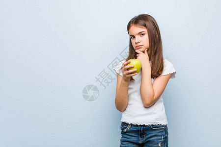 小caucasian女孩拿着绿色苹果图片