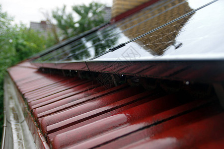 屋顶瓦片上的湿太阳能电池板图片