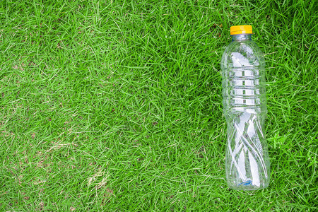 绿草背景下的塑料瓶回收与污染概念图片