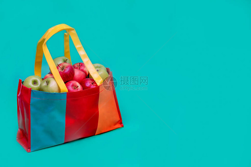 红色和绿色的苹果装在五颜六色的回收塑料袋里回收塑料袋运动广告和健康生活理图片