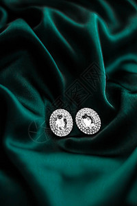 珠宝品牌优雅时尚和新娘奢华礼物概念深翡翠绿丝绸上的豪华钻石耳环节日图片