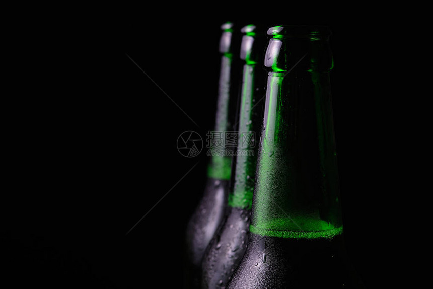 黑色背景的三瓶冰啤酒被图片