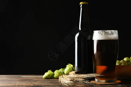 木桌上的啤酒小麦和啤酒花图片