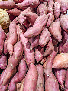 美味新鲜的紫色红薯堆放在超市商店出售供图片