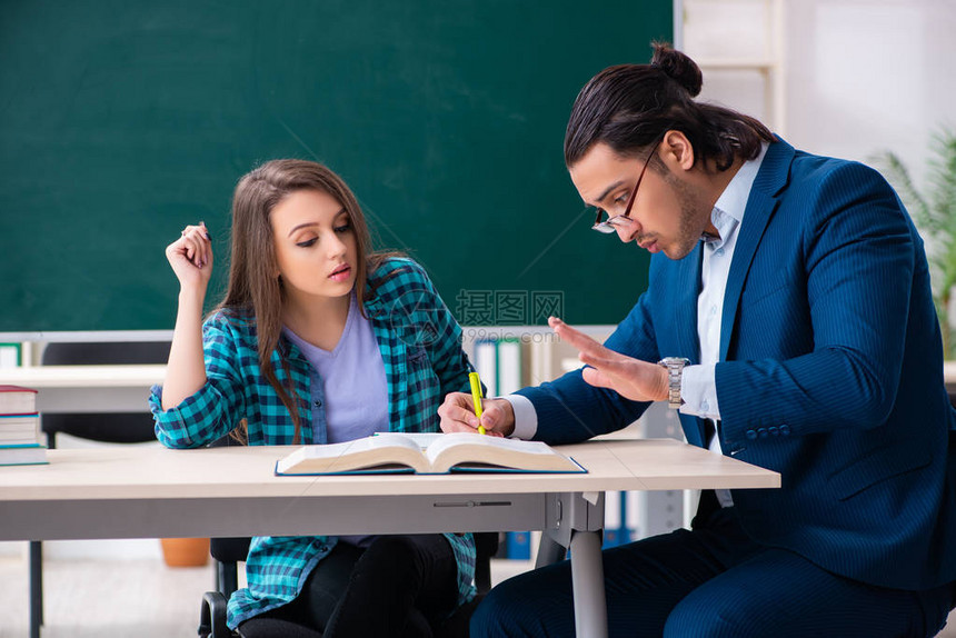 年轻英俊的教师和教室中的女学图片